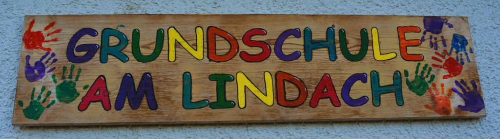 Holzschild imt der Aufschrift "Grundschule am Lindach"